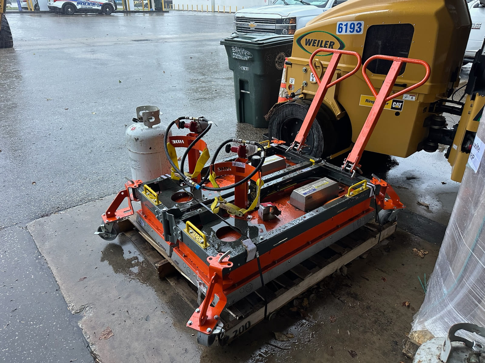 Heat Design infrared asphalt heating equipment mounted on a pallet beside a Weiler paver