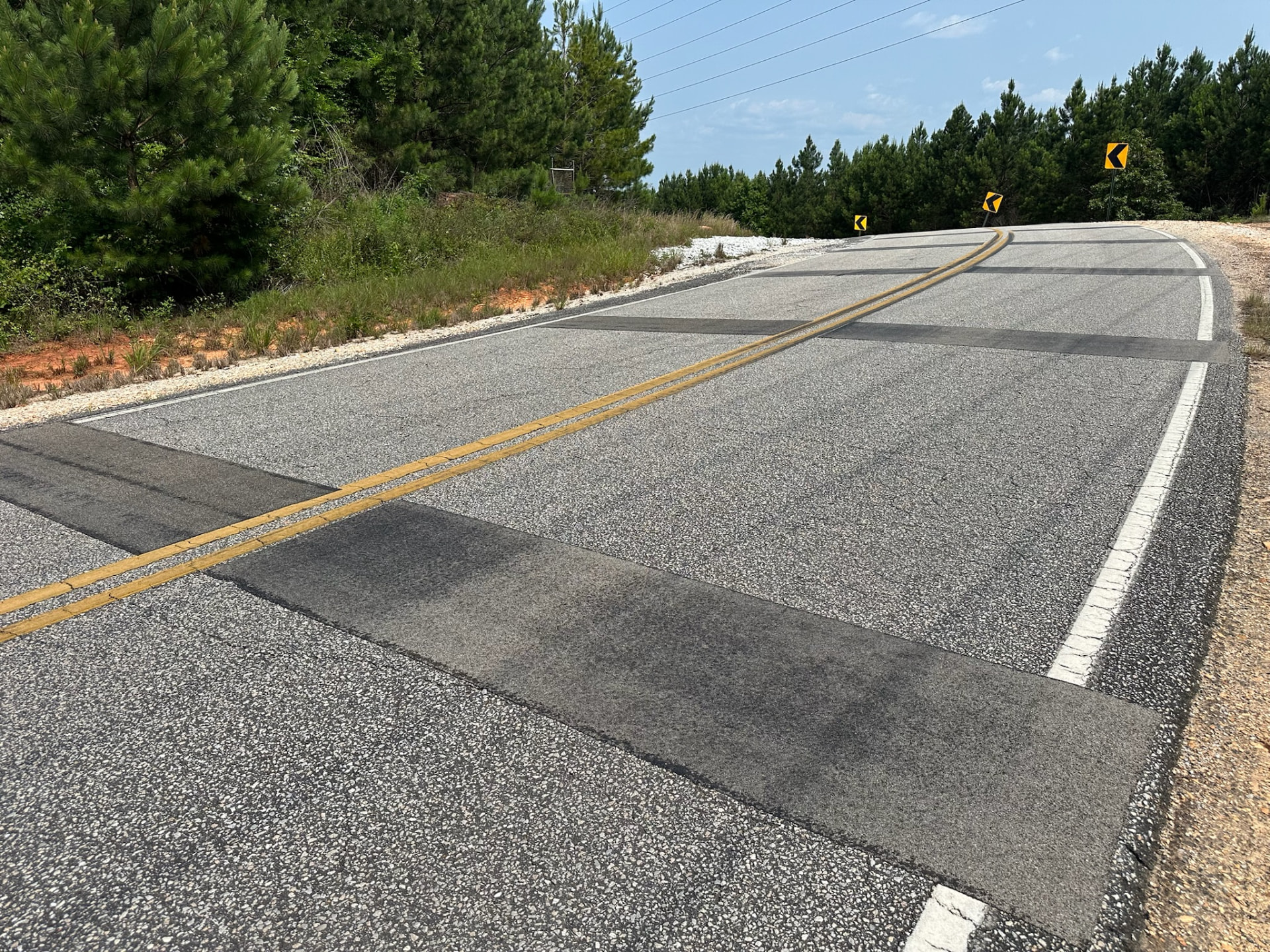Roadway Safety Strip installation following the negative-camber curve on Lee Road 151 in Alabama